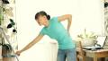 Woman having back pain during cleaning floor with mop