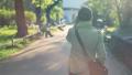 Woman walking in the park and talking on mobile phone, steadicam shot HD