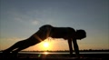 woman flexing her back at sunset