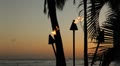 Tiki torch flames with sunset sky
