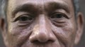 Eyes and face of serious old asian man looking at camera