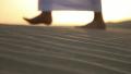 Weary wayfarer goes in the desert at sunset
