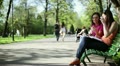 Two young college friends using a smart phone, outdoors, tracking shot HD