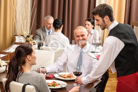 Stock photo of business lunch waiter serving red wine