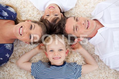 Smiling Young Family Lying On The Floor