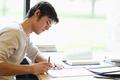 Serious male student writing