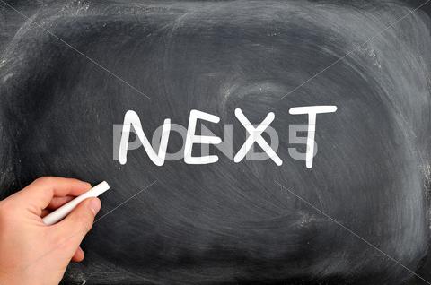 Stock photo of next written on a blackboard