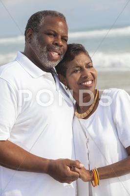 Stock photo of happy senior african american couple on beach