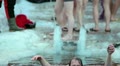 Modern adult man with mobile phone dipping in ice-hole, Epiphany, Russia Video