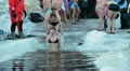 Young woman in ice-hole dipping in ice water in Epiphany Video