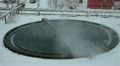 Huge round tanks for waste water treatment with steam over in factory Video