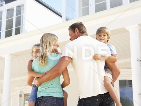 Young Family Standing Outside Dream Home