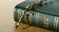 Rosary beads falling onto bible on a table