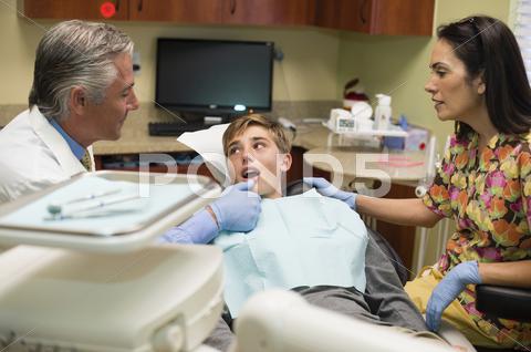 Dentist And Nurse Examining Patient's Mouth
