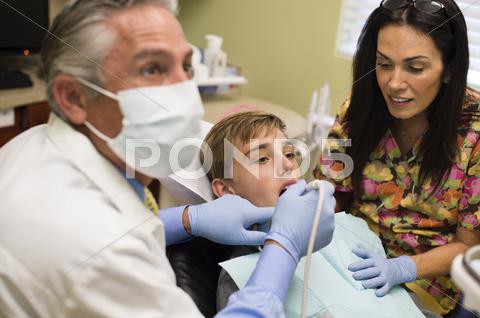 Dentist And Nurse Examining Patient's Mouth