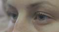 young woman closes and opens her beautiful blue eyes - macro Video