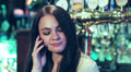 woman at the pub receives a call on his cell phone Video