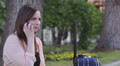 a young woman with a suitcase is on the phone and she is laughing with joy Video