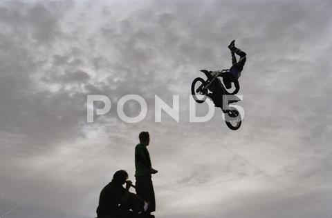 Person Riding Motorcycle And Performing Extreme Stunt In Mid-Air