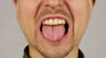 man compresses teeth and bites his tongue