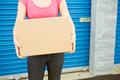 storage: woman with box stands by door