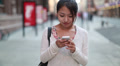 Asian woman walking talking texting cellphone smartphone