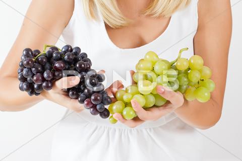 Stock photo of woman holding grapes