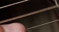 thumb strike the string on the guitar, guitar soundboard, closeup