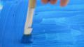 Painting with a blue color at paintbrush on blue painting.