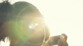 woman taking photographs using mobile phone sunset