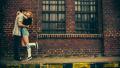 Teenage couple kissing in front of old industry building