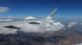 Airplane wing above the clouds and mountains