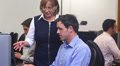 Teacher helping mature student in computer class