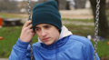Sorrowful teenage boy swinging in the park episode 1