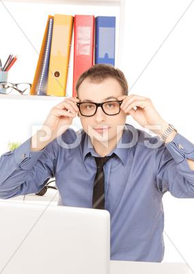Stock photo of businessman with laptop computer in office