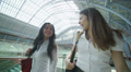 Attractive female friends walking through iconic London railway station