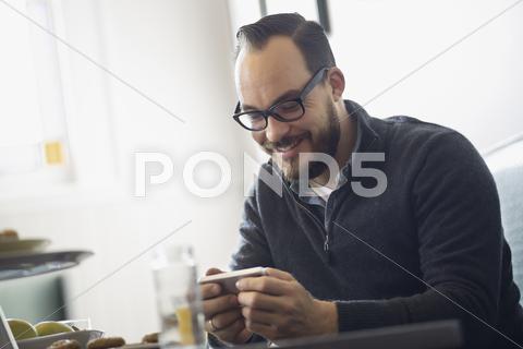 One Person Sitting At A Table In A Coffeeshop. A Bearded Man Having A Drink O