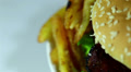Hamburger with fried potato in rotation on white background. Macro Video