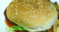 Hamburger with fried potato in rotation. Macro Video