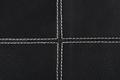 black leather background stitched up by white thread