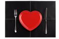 empty red heart plates with knife and fork on black leather