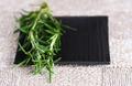 fresh rosemary on a black plate and rustic knitted fabric backgr