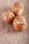three white new potatoes on brown hessian rustic background