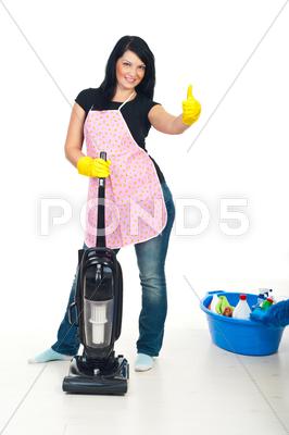 Stock photo of Woman with vacuum cleaner gives thumbs