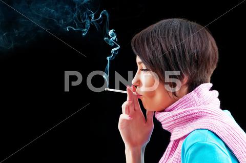 Stock photo of Young girl smoking on black