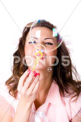 Stock photo of pretty girl blowing soap bubbles