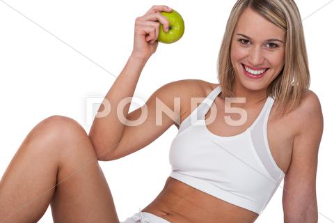 Stock photo of Fitness series - Smiling woman with green apple