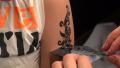 Applying a tattoo on the arm of the girl. 4K. Video