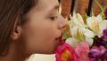 Happy girl smelling flowers while her boyfriend sleeps in bed Video