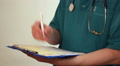 Doctor taking notes on clipboard, filling medical form, report Video